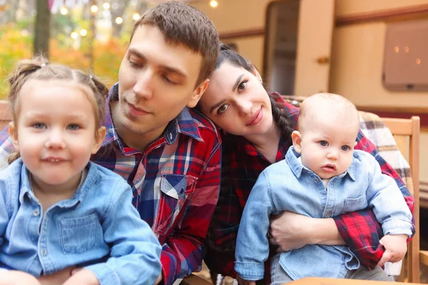 屋外の車輪で家の近くに抱擁しながら 若い笑顔の家族の肖像画 — ストック写真