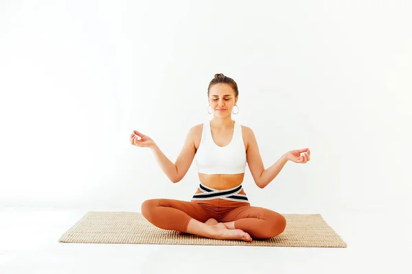 Junge Frau Sportbekleidung Sitzt Mit Überkreuzten Beinen Und Mudra Händen — Stockfoto