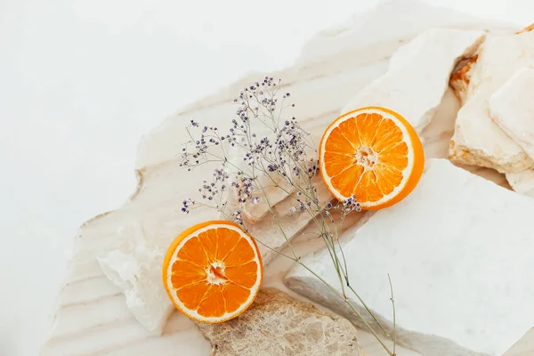 Van Bovenaf Van Helften Van Rijpe Sinaasappelen Delicate Bloemen Geplaatst — Stockfoto