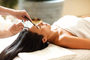 Kaplıca salonundaki Asyalı kadın için yüz masajı ya da güzellik tedavisi