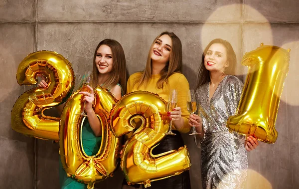 Glamorosas Hembras Jóvenes Sosteniendo Brillantes Globos Dorados Números 2021 Sonriendo —  Fotos de Stock