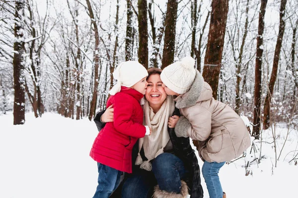 Små Jenter Yttertøy Kysser Lykkelig Kvinne Kinnene Mens Hviler Vinterskogen – stockfoto