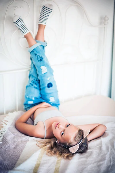 Досить маленька блондинка дівчинка-підліток лежить на ліжку . — стокове фото