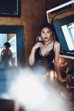 Güzel genç kadın kırmızı şarap cam tutan baştan çıkarıcı iç çamaşırı karışık ırk.