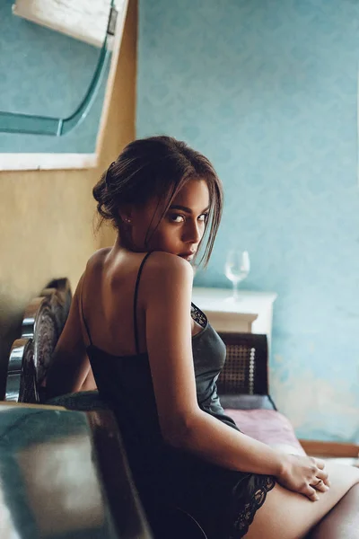 Bella giovane donna razza mista in lingerie seducente seduta su divano vintage. Boudoir ritratto di donna francese . — Foto Stock