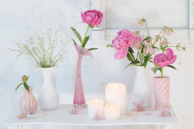 çiçek vazolar ve beyaz zemin üzerine mumlar