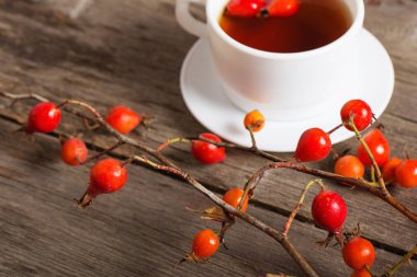 çilek dogrose ve ahşap arka plan üzerinde çay