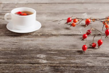 çilek dogrose ve ahşap arka plan üzerinde çay