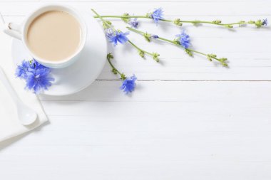 Hindiba beyaz tahta masada bir fincan içmek