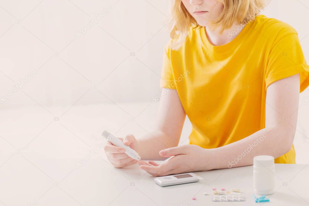 girl teenager measures blood sugar level