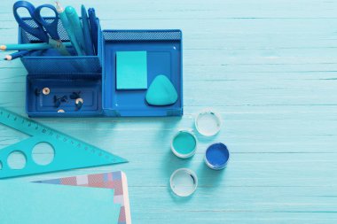 Mavi ahşap zemin üzerine mavi okul malzemeleri topluluğu