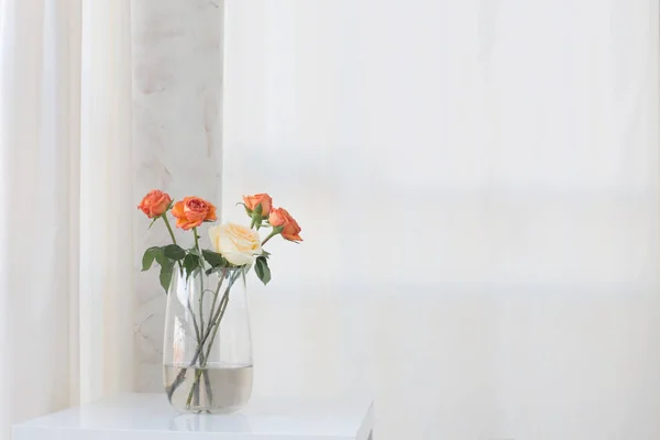 roses in vase on white table
