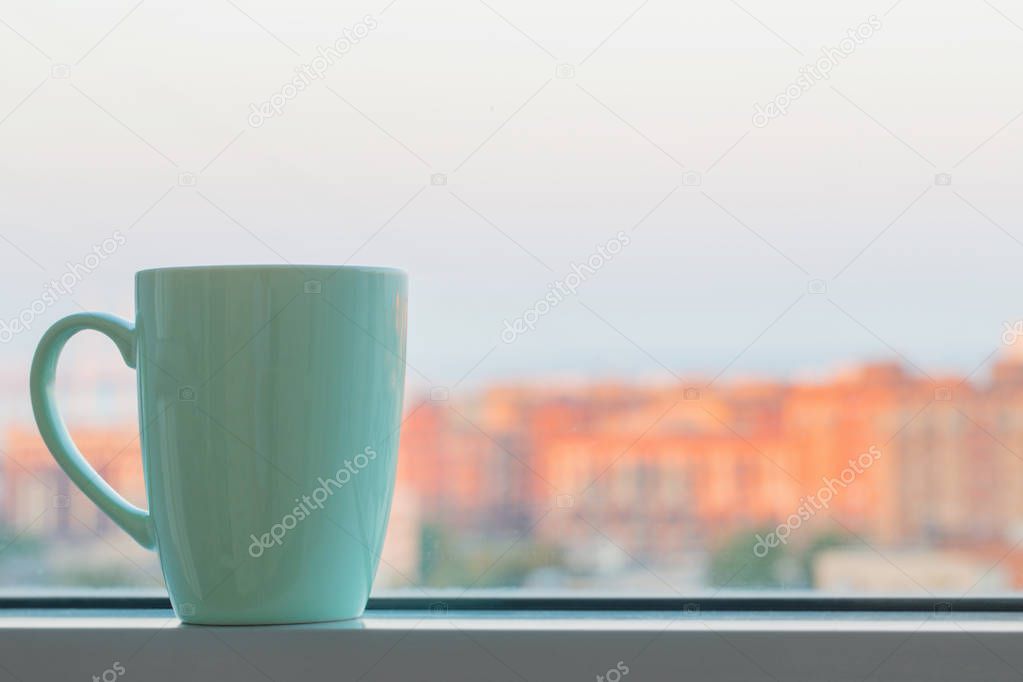 green cup on windowsiil in city
