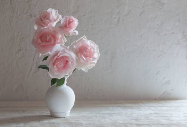 Beyaz arka plan üzerinde vazoda pembe Gül