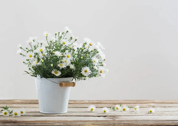 white flowers on bucket on wooden table