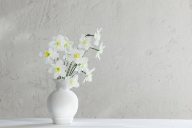 ahşap masa üzerinde vazoda beyaz nergis