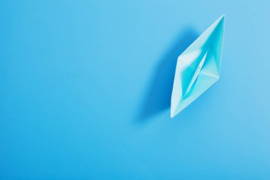 kağıt tekne mavi kağıt arka plan üzerinde