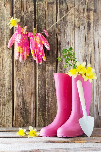 ゴム長靴と木製の背景の春の花 — ストック写真