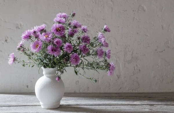 白色花瓶上的紫罗兰花在老白色背景上 — 图库照片