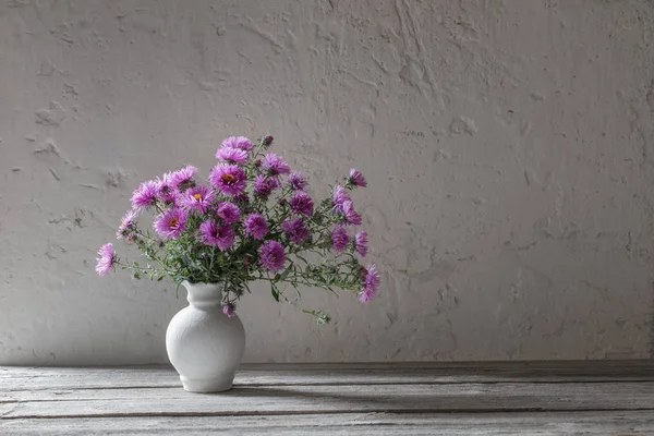 白色花瓶上的紫罗兰花在老白色背景上 — 图库照片