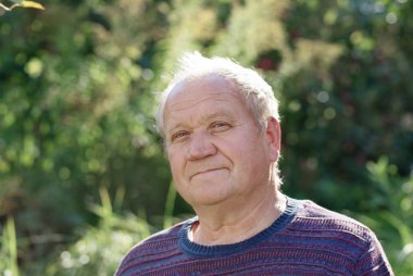 Güneşli sonbahar parkta yaşlı adam portresi