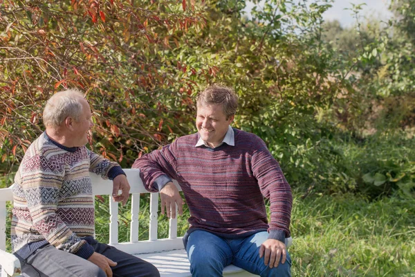 Vater Und Sohn Sitzen Auf Bank Herbstlich Sonnigen Park — Stockfoto