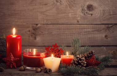 Noel dekorasyon ahşap arka plan üzerinde kırmızı mumlar ile