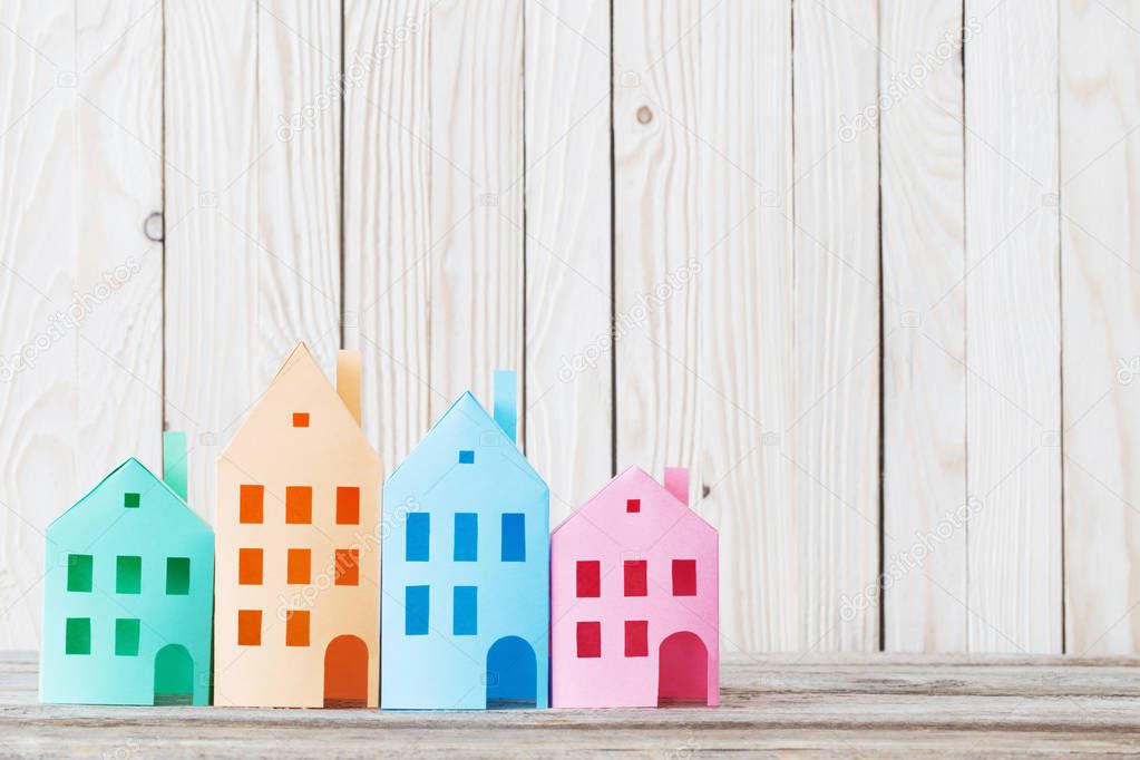 paper houses on light wooden background
