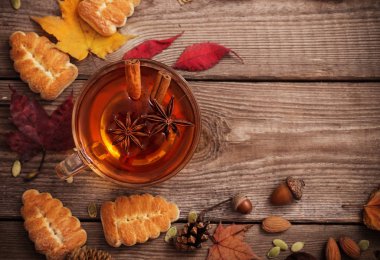 tanımlama bilgileri ve eski ahşap arka plan üzerinde sonbahar yaprakları ile çay