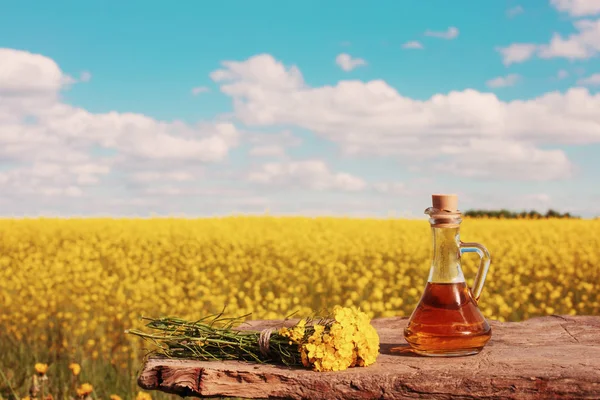 rapeseed oil on wooden table in field