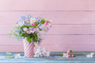 Tahta arka planda vazoda bahar çiçekleri