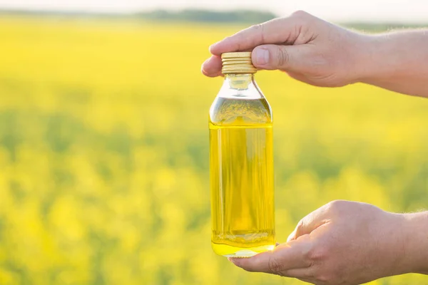 Aceite Colza Botella Mano Campo Violación Fondo — Foto de Stock