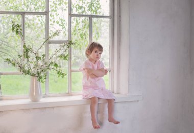 bahar çiçekleri ile eski pencere güzel küçük kız