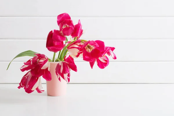 木製の白い背景の上に花瓶でピンクのチューリップ — ストック写真