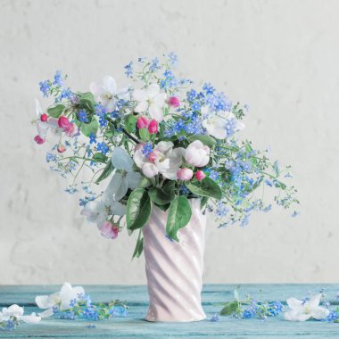 Beyaz arkaplanda vazoda bahar çiçekleri