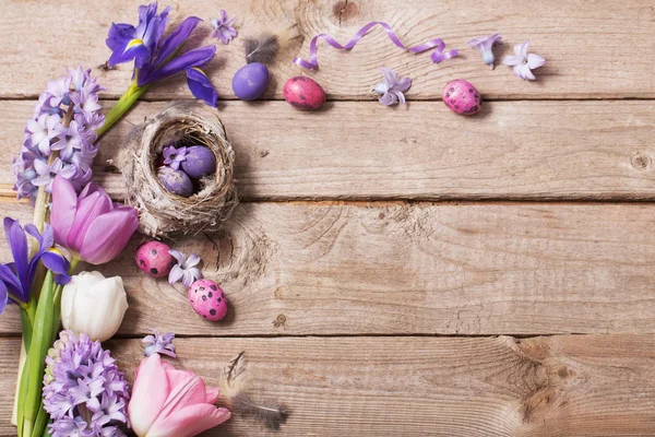 Ahşap arka plan bahar çiçekleri ile Paskalya yumurtaları