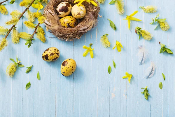 复活节彩蛋在巢与黄色的花在木背景 — 图库照片