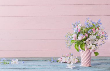 Tahta arka planda vazoda bahar çiçekleri