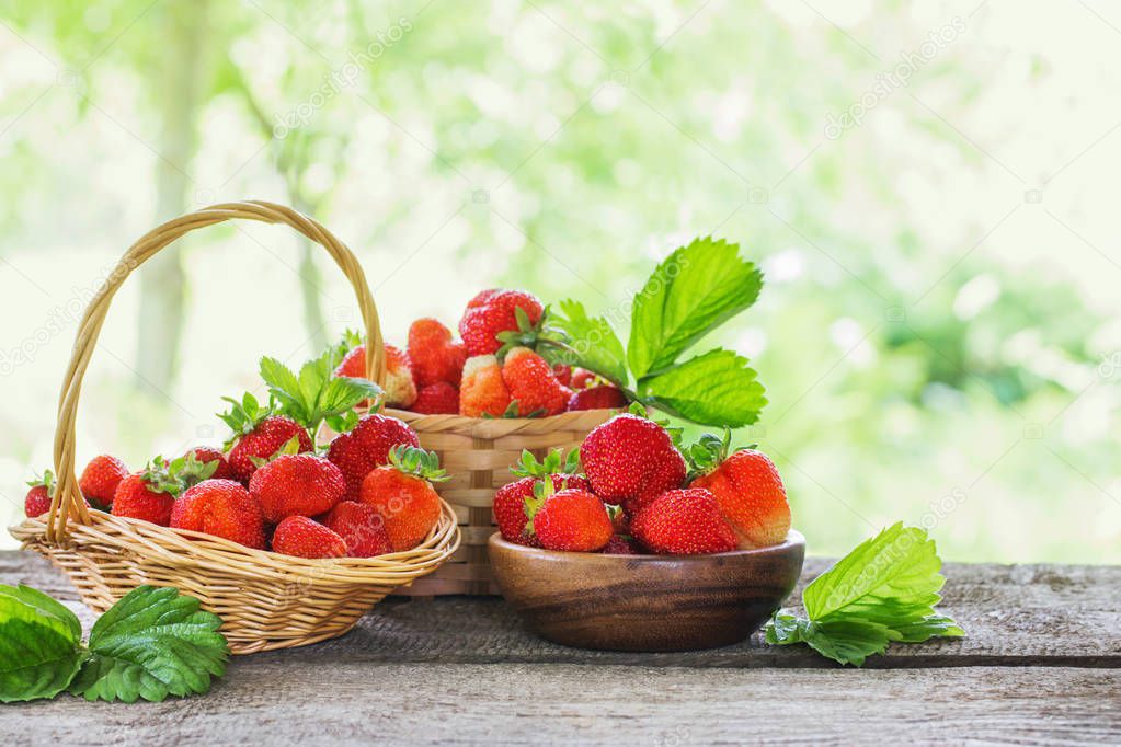 strawberries in baskets on wooden table outdoor