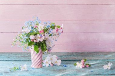 Tahta arka planda vazoda bahar çiçekleri