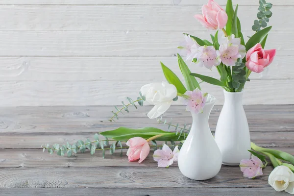 春天花在白色花瓶在白色木背景 — 图库照片