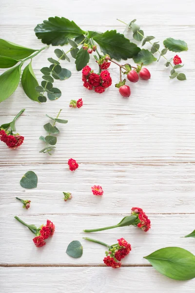 Czerwone kwiaty z liści na białym tle drewnianych — Zdjęcie stockowe