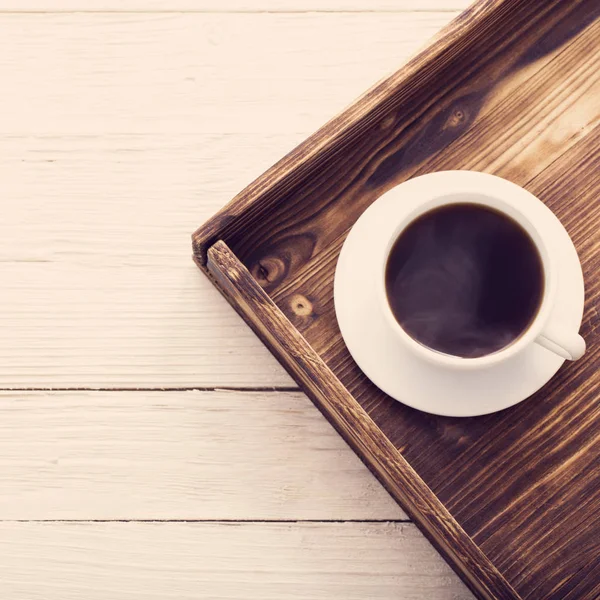 Taza de café en bandeja sobre mesa de madera —  Fotos de Stock
