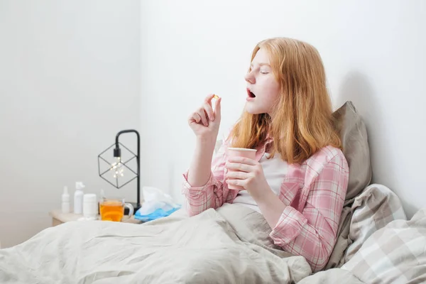Κορίτσι παίρνει το χάπι στο υπνοδωμάτιο — Φωτογραφία Αρχείου