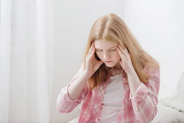 Adolescente chica con dolor de cabeza en el dormitorio —  Fotos de Stock