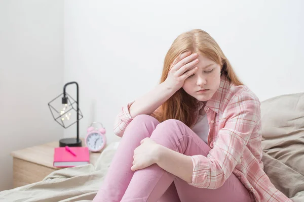 Tiener meisje met hoofdpijn in slaapkamer — Stockfoto