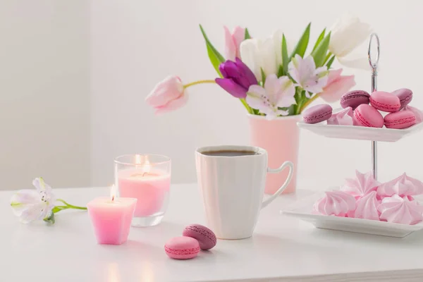 Tulpen in Vase und Tasse Kaffee mit Dessert auf weißem Hintergrund — Stockfoto