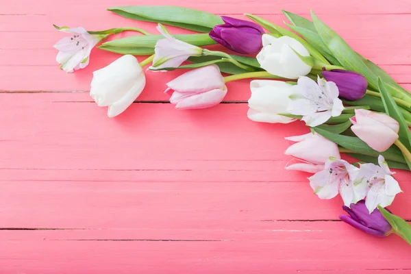 Květiny tulipány na růžové dřevěné pozadí — Stock fotografie