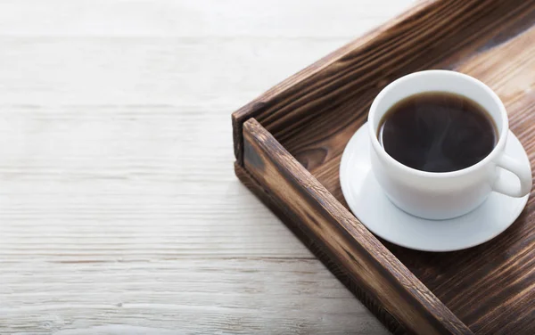 Taza de café en bandeja sobre mesa de madera — Foto de Stock
