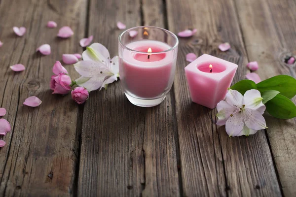 Candele rosa e fiori su sfondo di legno — Foto Stock